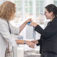 faculty smiling and shaking hands
